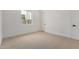 Clean bedroom with neutral carpet, white walls, a window and a white door at 10308 E Utah Ave, Mesa, AZ 85212