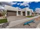 Contemporary home featuring a three car garage and a well-manicured lawn at 10308 E Utah Ave, Mesa, AZ 85212