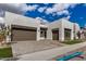 Contemporary home featuring a three car garage and a well-manicured lawn at 10308 E Utah Ave, Mesa, AZ 85212