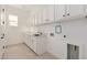 Spacious laundry room with white cabinets, sink, and modern appliances at 10308 E Utah Ave, Mesa, AZ 85212