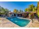 Beautiful pool with fountain features and patio area, surrounded by lush greenery and flowering bushes at 105 E Claremont St, Phoenix, AZ 85012