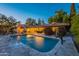 Sparkling swimming pool with a waterfall feature, surrounded by a stone patio, ideal for relaxation at 105 E Claremont St, Phoenix, AZ 85012