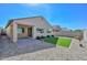 Exterior view of the backyard showcasing a covered patio, artificial grass and desert landscaping at 10730 W Escuda Dr, Peoria, AZ 85373
