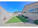 A private backyard featuring artificial turf, desert landscaping, and a block fence at 10730 W Escuda Dr, Peoria, AZ 85373