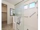 Modern bathroom with tiled floors, a glass shower enclosure, and an adjacent closet for added convenience at 10730 W Escuda Dr, Peoria, AZ 85373