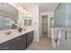 Elegant bathroom featuring double sinks, tiled flooring, and a stylish glass-enclosed shower at 10730 W Escuda Dr, Peoria, AZ 85373