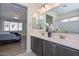 Bright bathroom boasts a double vanity with modern fixtures, with the main bedroom visible in the mirror at 10730 W Escuda Dr, Peoria, AZ 85373