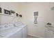 Laundry room featuring a washer and dryer, complemented by decorative wall hangings and organized shelving at 10730 W Escuda Dr, Peoria, AZ 85373