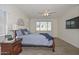 Well-lit main bedroom features a ceiling fan, hardwood floors, and a window with serene views at 10730 W Escuda Dr, Peoria, AZ 85373