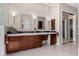Well-lit bathroom with dual sinks, framed mirrors, and dark wood cabinetry at 11664 E Del Timbre Dr, Scottsdale, AZ 85259
