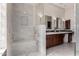 Bright bathroom with a walk-in shower, bench seating, and dual sink vanity with framed mirrors at 11664 E Del Timbre Dr, Scottsdale, AZ 85259