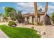 Charming single-story home featuring desert landscaping with mature trees, rock features and a lush lawn at 11664 E Del Timbre Dr, Scottsdale, AZ 85259