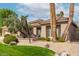 Charming single-story home featuring desert landscaping with mature trees, rock features and a lush lawn at 11664 E Del Timbre Dr, Scottsdale, AZ 85259