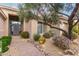 Inviting entrance featuring desert landscaping and a paved walkway leading to an arched glass accented front door at 11664 E Del Timbre Dr, Scottsdale, AZ 85259