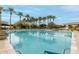 A large community pool with swimming lanes is framed by palm trees and lounge chairs at 11664 E Del Timbre Dr, Scottsdale, AZ 85259