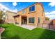 A spacious backyard featuring a covered patio, artificial turf, and partial fence at 12462 N 75Th Ln, Peoria, AZ 85381