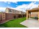 Open backyard featuring synthetic grass, brick fence, and covered patio area at 12462 N 75Th Ln, Peoria, AZ 85381