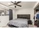 Serene bedroom featuring a dark bed frame, modern ceiling fan, and soft carpeting, offering a peaceful retreat at 1253 E Avila Ave, Casa Grande, AZ 85122