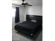 Clean modern bedroom showcasing a platform bed with black bedding, a ceiling fan, and a window at 1253 E Avila Ave, Casa Grande, AZ 85122