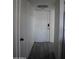 Bright hallway with white walls, leading to a white door with a modern lock at 1253 E Avila Ave, Casa Grande, AZ 85122