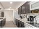 Well-equipped kitchen with stainless steel appliances, sleek countertops, and dark cabinetry, with a view into the living space at 1253 E Avila Ave, Casa Grande, AZ 85122
