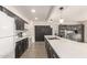 Stylish kitchen featuring dark cabinets, stainless steel appliances, a spacious counter, and attractive modern lighting at 1253 E Avila Ave, Casa Grande, AZ 85122