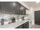 Modern kitchen featuring dark cabinetry, stainless steel appliances, mosaic backsplash, and bright countertops at 1253 E Avila Ave, Casa Grande, AZ 85122