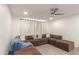 Comfortable living room featuring a large sectional sofa, neutral decor, and modern ceiling fan, ideal for relaxation at 1253 E Avila Ave, Casa Grande, AZ 85122