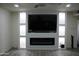 Modern living room with a sleek fireplace, built-in shelving, recessed lighting and stylish flooring at 1253 E Avila Ave, Casa Grande, AZ 85122