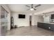 Open-concept living area featuring sleek flooring, a wall-mounted TV, and a stylish breakfast bar connecting the kitchen at 1253 E Avila Ave, Casa Grande, AZ 85122