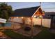 This backyard has a wooden pergola with string lights, a firepit and a view of the swimming pool at 1253 E Avila Ave, Casa Grande, AZ 85122