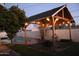 This backyard has a wooden pergola with a brick base, string lights, an orange tree and a view of the pool at 1253 E Avila Ave, Casa Grande, AZ 85122