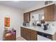 Bright kitchen featuring wood cabinets, white countertops, and a breakfast bar pass-through at 13642 N Silverbell Dr, Sun City, AZ 85351