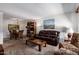 Spacious living room with a leather sofa, patterned chairs, and an adjacent dining area at 13642 N Silverbell Dr, Sun City, AZ 85351