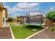 Spacious backyard featuring a pergola-covered patio, trampoline, and lush lawn for outdoor enjoyment at 14845 W Georgia Dr, Surprise, AZ 85379