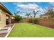 Spacious backyard boasts a well-manicured lawn, mature trees, and string lights for idyllic outdoor experience at 14845 W Georgia Dr, Surprise, AZ 85379