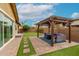 Spacious backyard boasts a well-manicured lawn, covered patio, and mature trees for idyllic outdoor enjoyment at 14845 W Georgia Dr, Surprise, AZ 85379