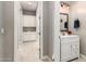 Well-lit bathroom vanity with decorative mirror, white cabinets, and tiled floor at 14845 W Georgia Dr, Surprise, AZ 85379