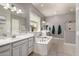 Bathroom featuring a large soaking tub, dual sinks, and a bright, airy feel with tile flooring at 14845 W Georgia Dr, Surprise, AZ 85379