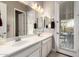 Well-lit bathroom with a double vanity and access to the outdoor at 14845 W Georgia Dr, Surprise, AZ 85379