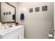 Bathroom featuring a vanity with white cabinets, decorative mirror, and humorous wall decor at 14845 W Georgia Dr, Surprise, AZ 85379