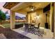 Inviting covered patio with ceiling fan, dining set, and view of the landscaped backyard at 14845 W Georgia Dr, Surprise, AZ 85379