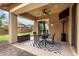 Inviting covered patio with ceiling fan, dining set, and view of the landscaped backyard at 14845 W Georgia Dr, Surprise, AZ 85379