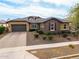 Charming single-story home featuring a stone facade, well-manicured landscaping, and a two-car garage at 14845 W Georgia Dr, Surprise, AZ 85379