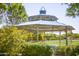 A charming gazebo with a blue roof offers a shaded retreat with manicured greenery and community lawn space at 14845 W Georgia Dr, Surprise, AZ 85379