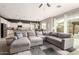 Bright, open-concept living room featuring a large sectional couch and backyard views at 14845 W Georgia Dr, Surprise, AZ 85379