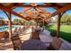 Relaxing pool area with lounge chairs, a beautiful pergola, and scenic green landscaping at 14845 W Georgia Dr, Surprise, AZ 85379