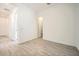 A bright, empty bedroom with wood-look tile flooring and an accessible walk-in closet at 15053 W Gray Fox Trl, Surprise, AZ 85387
