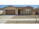 Charming single-story home with a two car garage and low maintenance desert landscaping in the front yard at 15053 W Gray Fox Trl, Surprise, AZ 85387