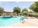 Community pool features a pergola with lush planters, shade umbrellas and lounge chairs at 15240 N 142Nd Ave # 1101, Surprise, AZ 85379